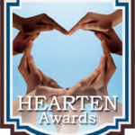 Hands forming a heart shape against a blue sky for Hearten Awards.